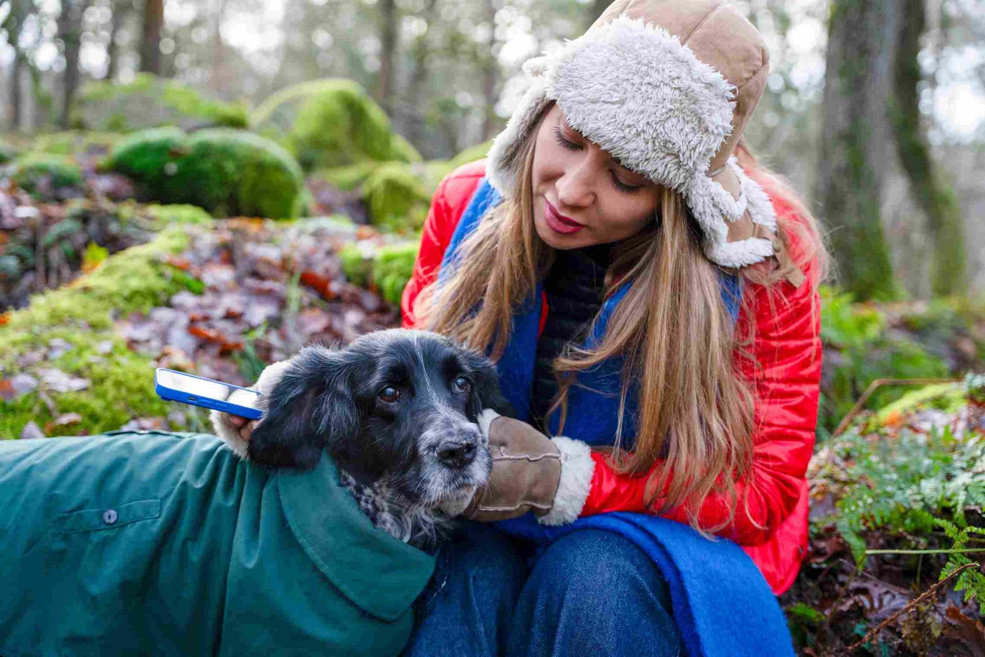 Quelle est la meilleure assurance pas trop cher pour chien: femme et son chien profitant d’un moment ensemble dans les bois lors d’une journée fraîche.
